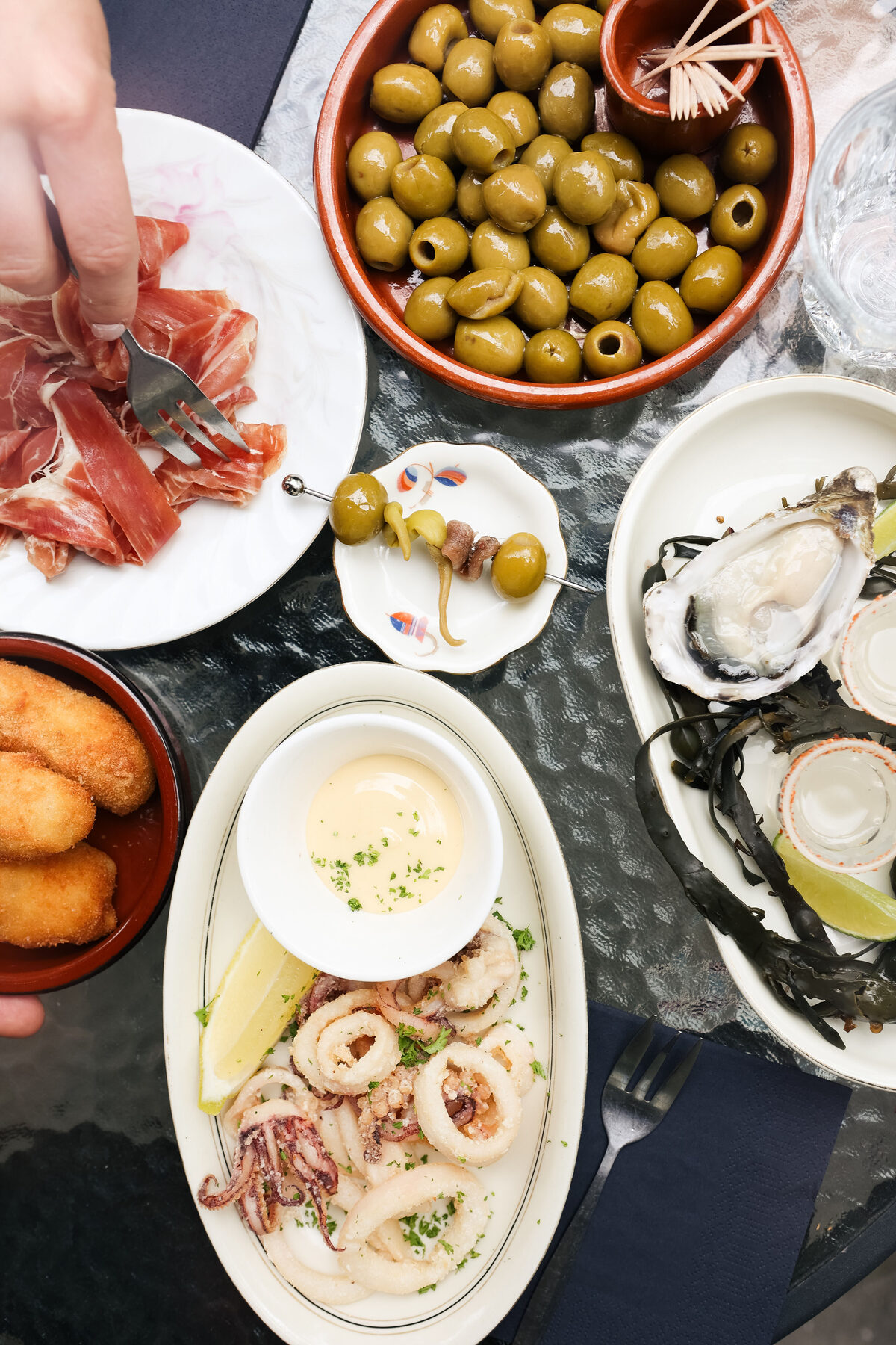 Oesters, olijven, ham, croquetas en calamares